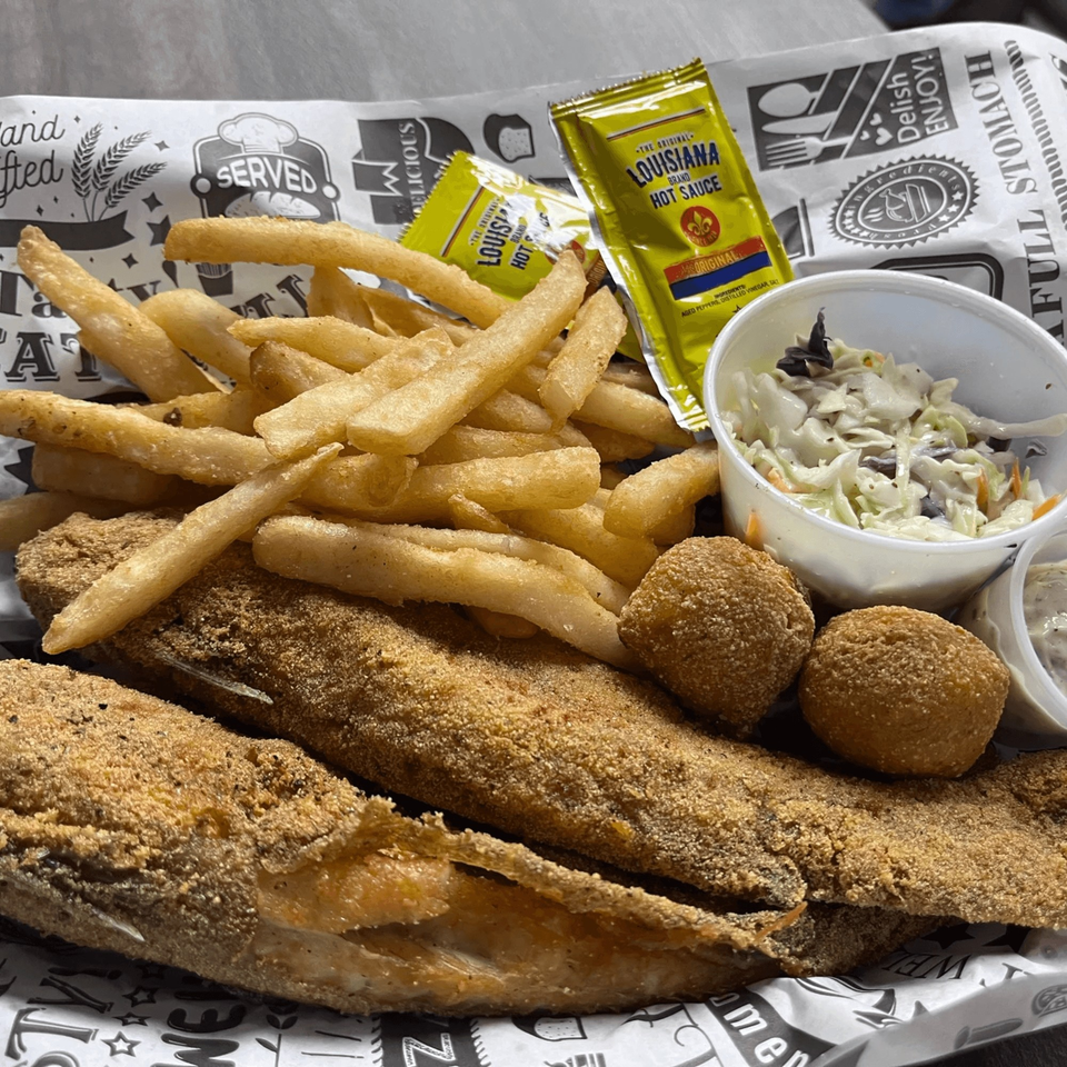 Delta Fish Market's fried fish, french fries, hush puppies, coleslaw, and Louisiana hot sauce.
